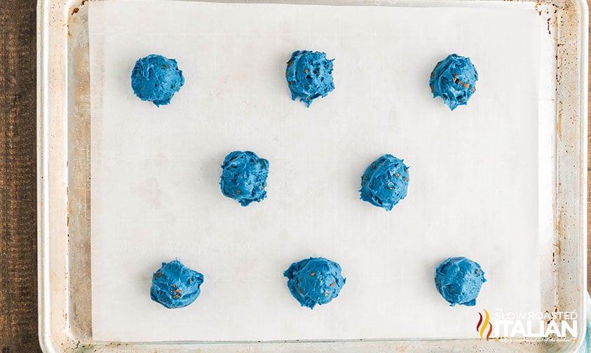 scoops of blue chocolate chip cookie dough on a baking sheet