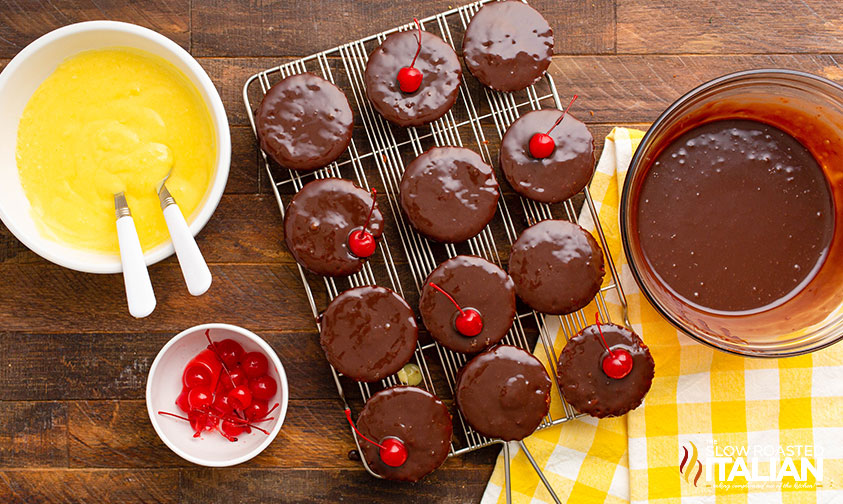 adding cherries to boston cream cupcakes