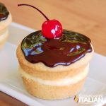 boston cream cupcake topped with a cherry on a serving tray
