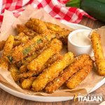 fried zucchini sticks on a plate with sauce for dipping