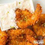 coconut butterfly shrimp on a plate with dipping sauce