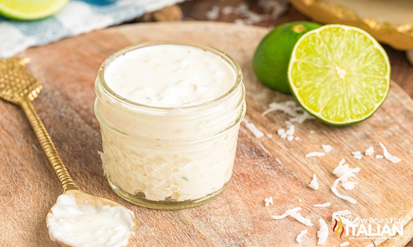 coconut shrimp dipping sauce in a mason jar with a lime sliced in half