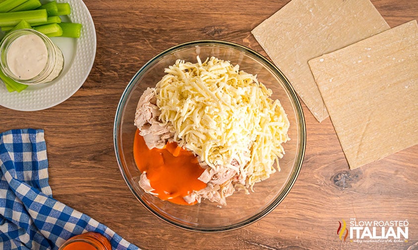 shredded chicken cheese and buffalo sauce in a mixing bowl