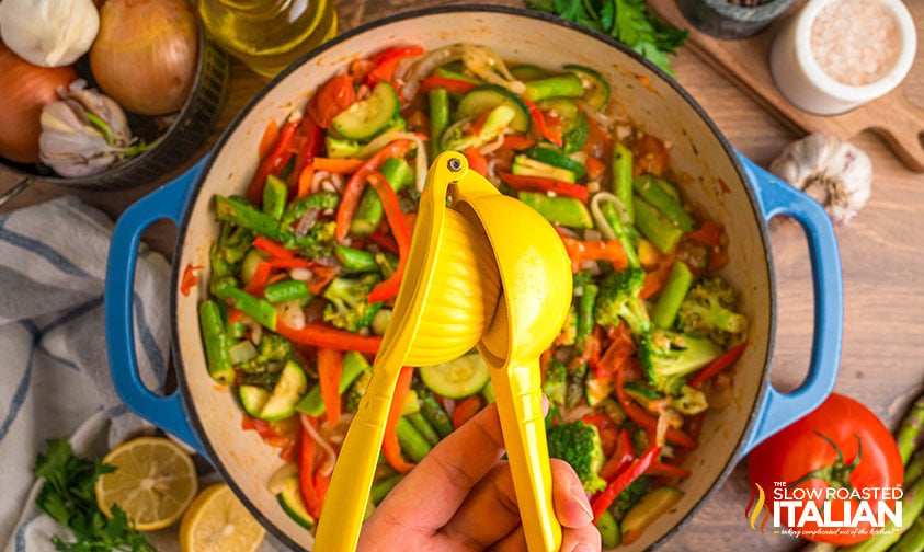 adding fresh lemon juice to vegetables in a large pot