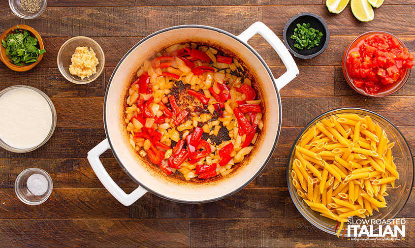 adding onions, peppers and seasoning to large pot