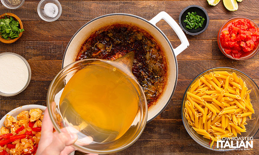 pouring chicken stock into large pot