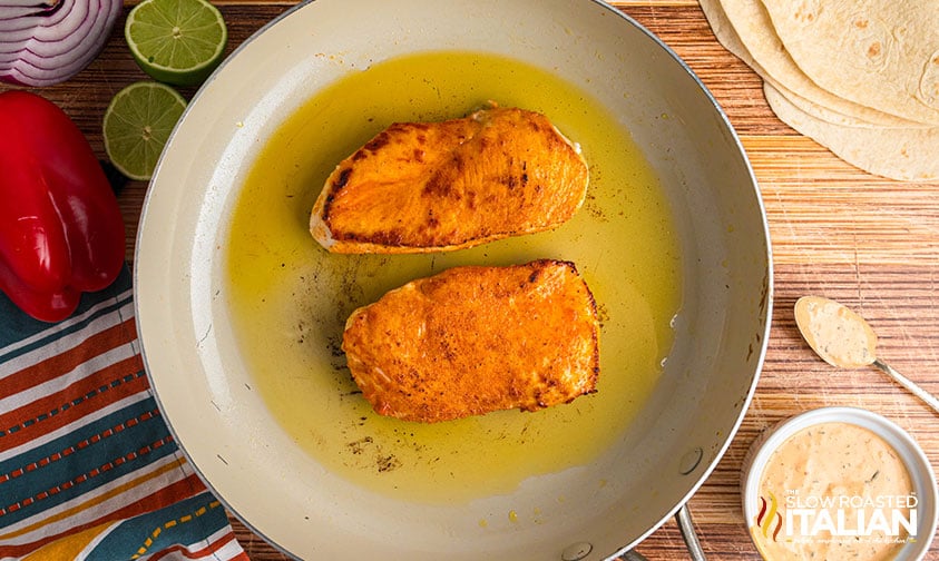 cooking chicken cutlets in a skillet with oil