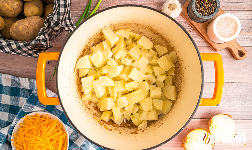 adding cut potatoes to a large pot