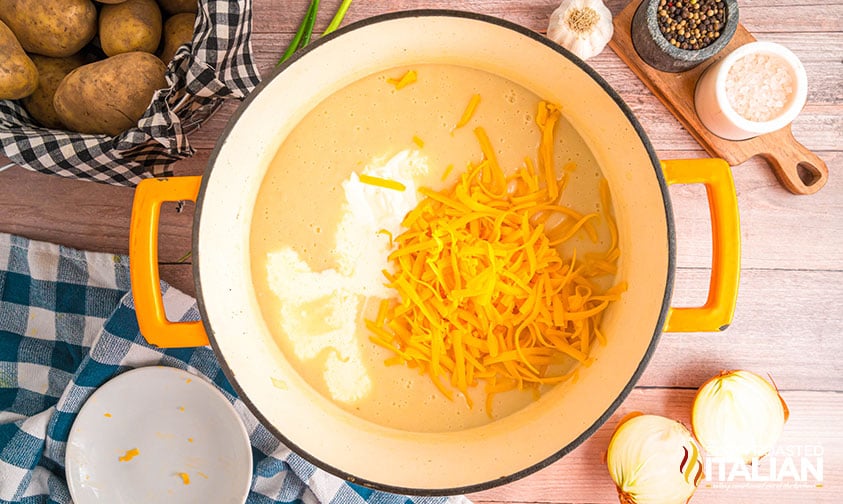 adding cheese and heavy cream to baked potato soup