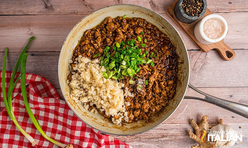 adding rice and green onions to ground chicken