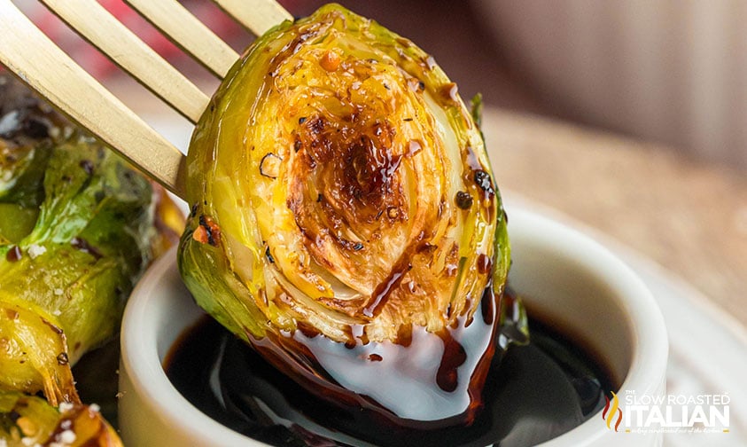 closeup of crispy brussel sprouts dipped in balsamic glaze