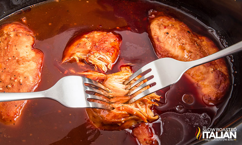 shredding chicken breasts with forks in a crockpot