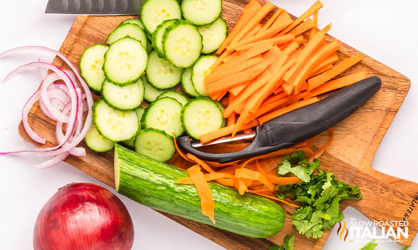 preparing cucumber, carrots and onions for carrot and cucumber salad