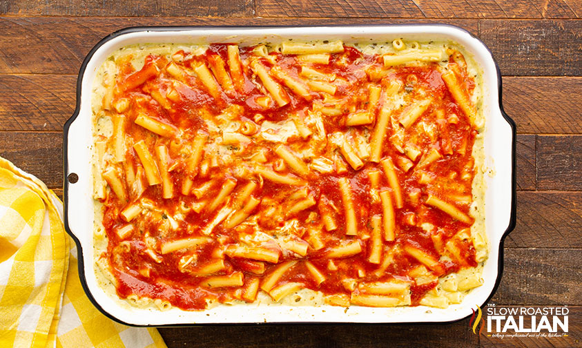 tomato sauce poured over pasta in baking dish