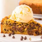 piece of chocolate chip cookie cake with a scoop of vanilla ice cream on top