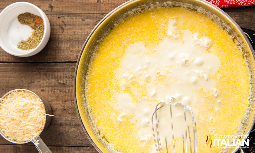 whisking heavy cream and cream cheese into melted butter