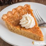 maple syrup pie on a plate with a dollop of whipped cream