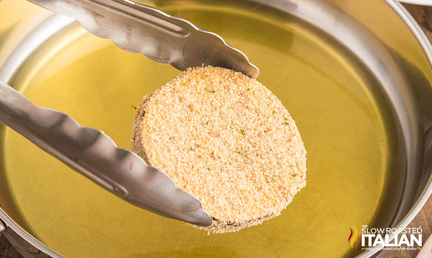 breaded eggplant parmesan going into hot oil