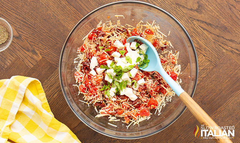 cheese, tomatoes and basil in a mixing bowl