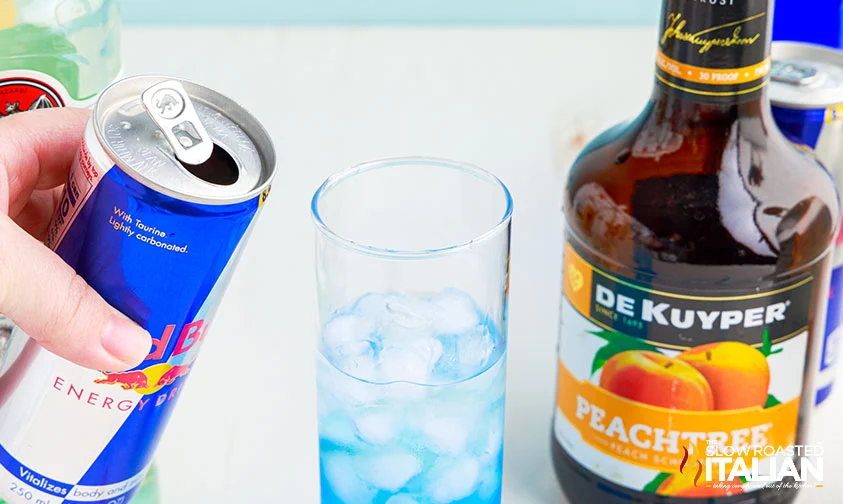 about to pour red bull can into trash can drink