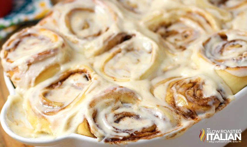 close up: pan of frosted homemade cinnabon cinnamon rolls