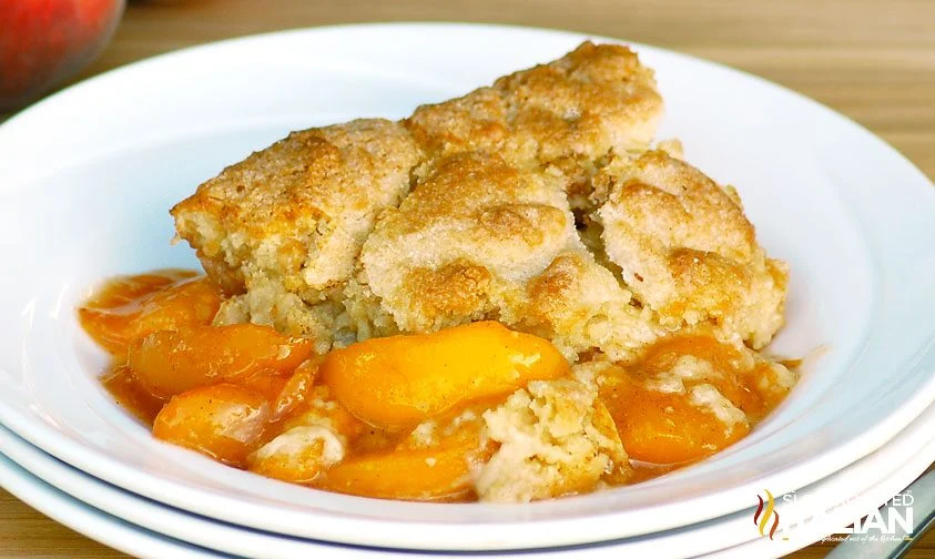 scoop of southern style peach cobbler on a stack of plates