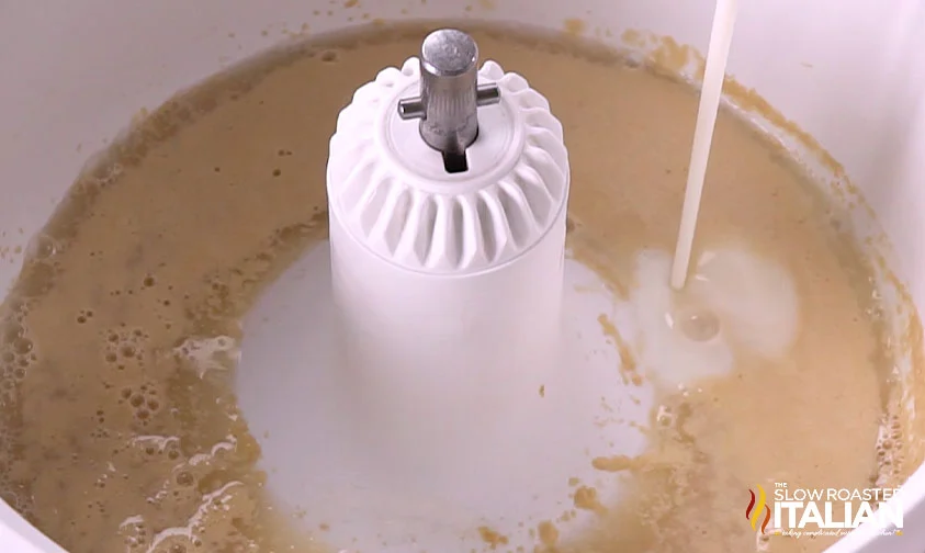 pouring buttermilk into dough base in mixer