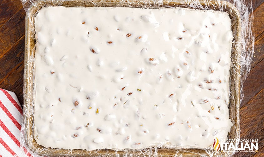 nougat candy mixture spread onto sheet pan lined with plastic wrap