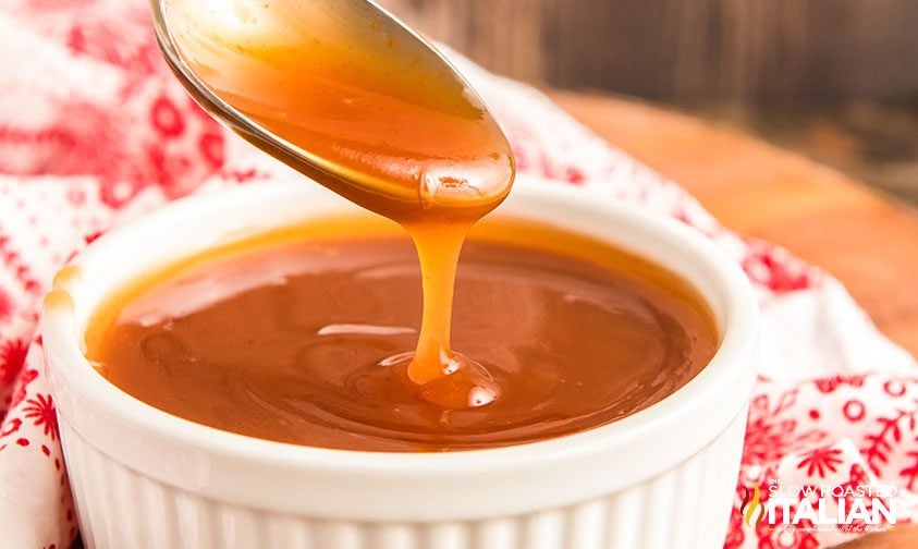 lifting spoon out of small ramekin of sweet n sour sauce