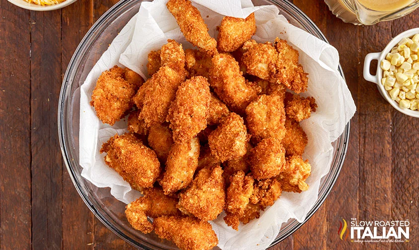 homemade popcorn chicken draining on paper towel in bowl