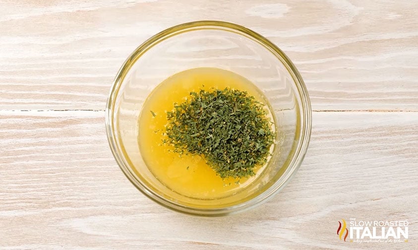 bowl of melted butter with dried parsley