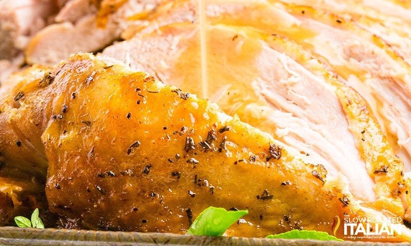 drizzling gravy over sliced crockpot turkey breast