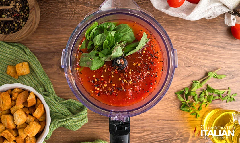 blending fresh basil, spices, and roasted tomatoes in food processor