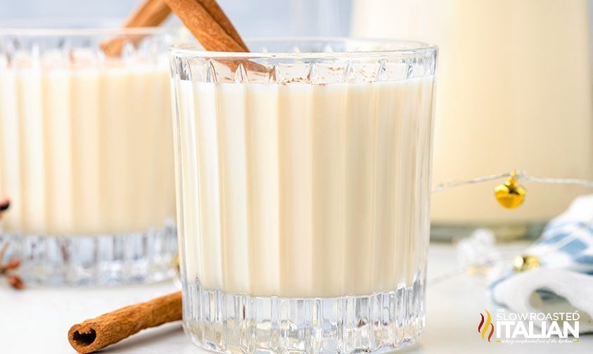 fancy glass tumblers of puerto rican eggnog and cinnamon stick garnish