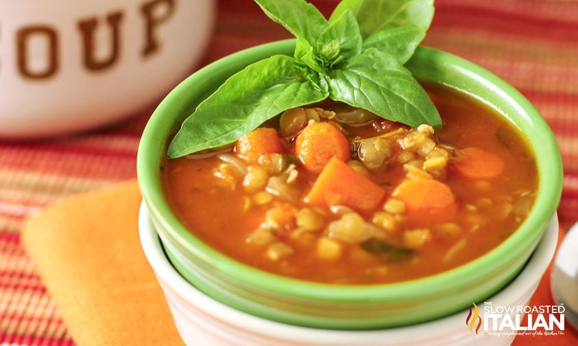 green bowl of italian lentil soup stacked inside of a white bowl