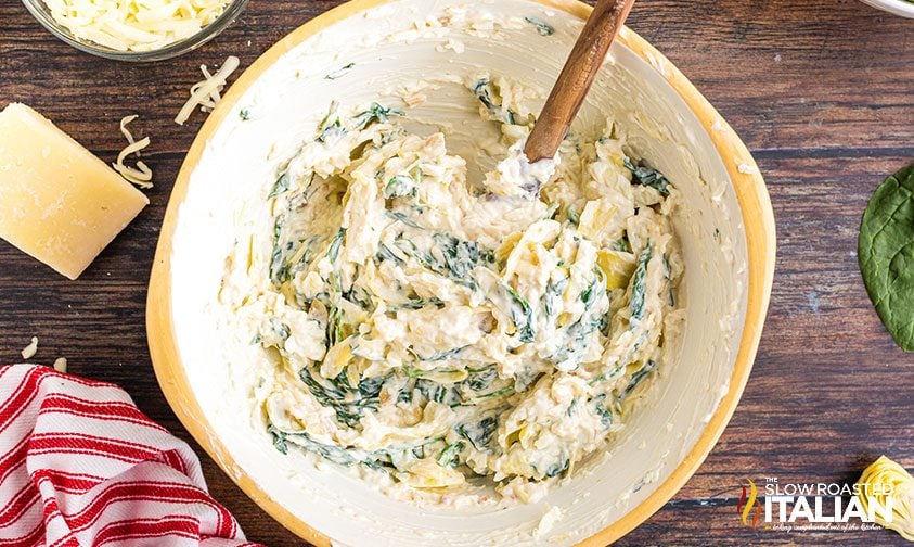 mixing artichoke spinach dip in a bowl