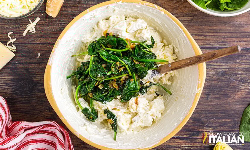 adding sauteed spinach, onions, and garlic to cheese dip
