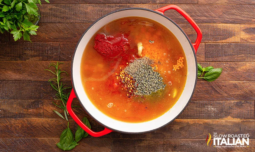 lentils, tomato paste, and spices in pot with other soup ingredients