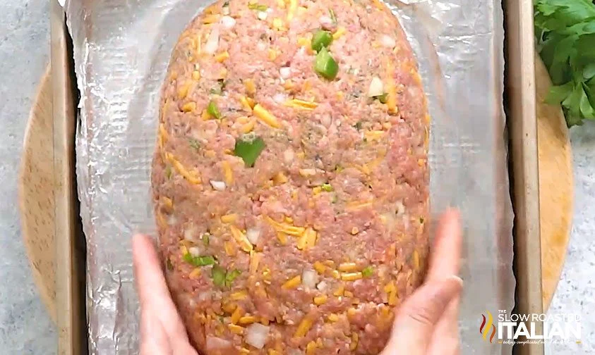 shaping Cracker Barrel meatloaf on foil-lined baking sheet