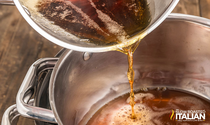 pouring maple syrup into a clean pot placed in an ice bath