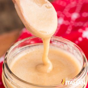 homemade maple cream drizzled off a spoon into a jar