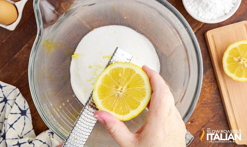zesting half a lemon into sugar in mixer bowl