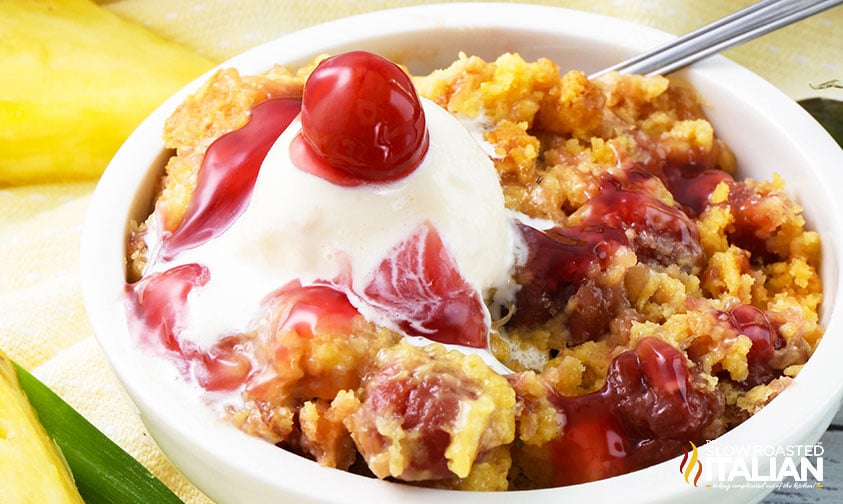 cherry dump cake with ice cream in white bowl