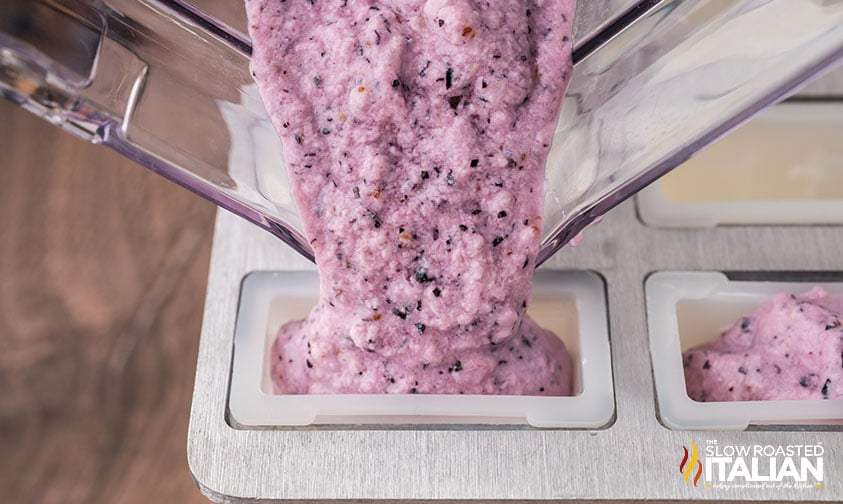 pouring blueberry popsicle mixture into ice pop mold