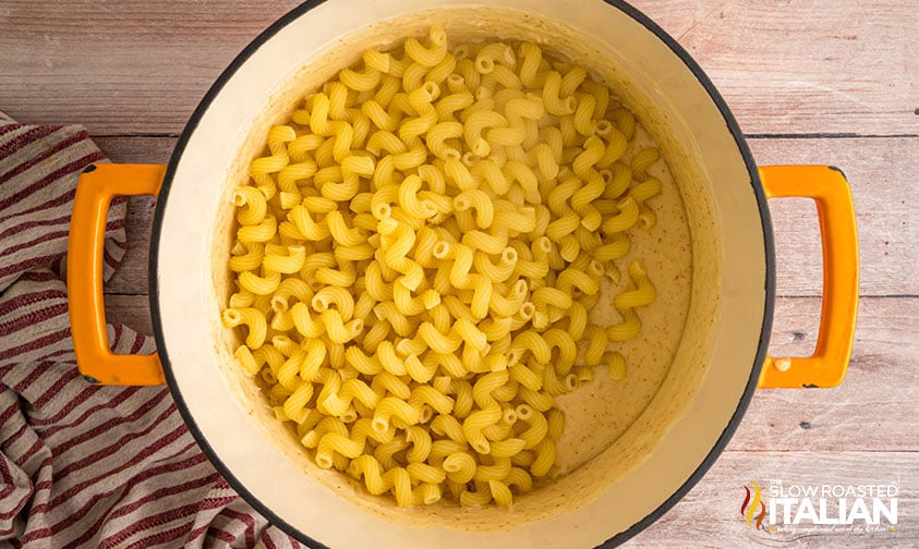 adding cooked pasta to cheese sauce for Costco Mac and Cheese Copycat Recipe
