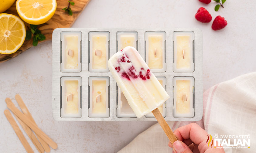 hand holding a lemon raspberry popsicle