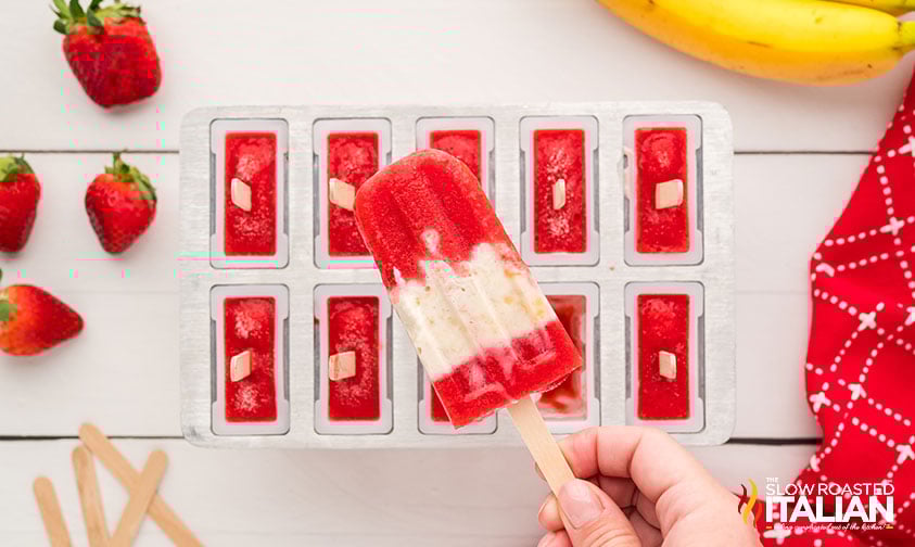 hand holding a strawberry banana popsicle