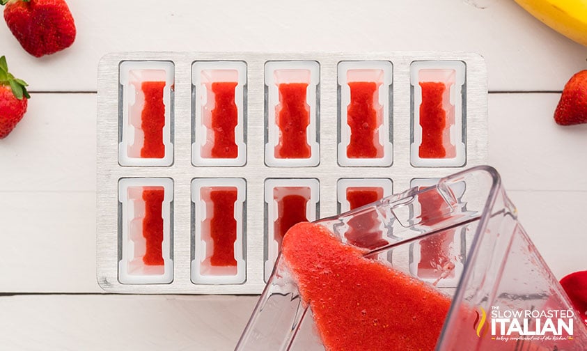 pouring strawberry mixture into ice pop molds