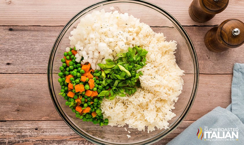 adding rice, peas, carrots, and onion to sauce in a large bowl
