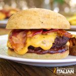 closeup of a barbecue bacon burger covered in gooey cheese